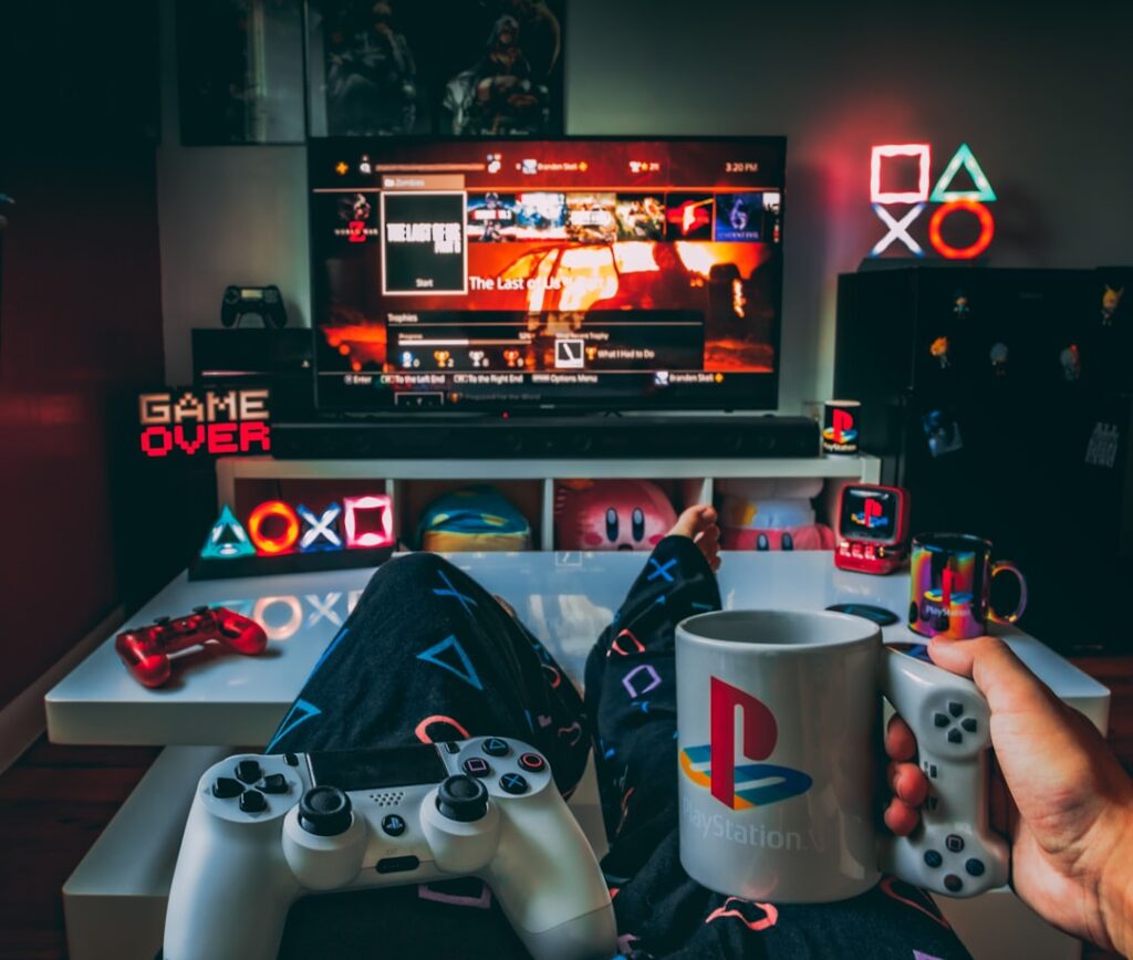 Person relaxing at home holding a mug and game controller